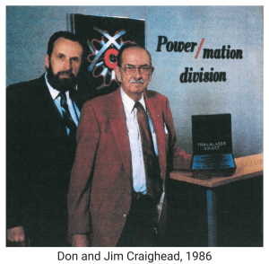 The two original owners of Power/mation wearing black and read suits standing next to black trailblazer award