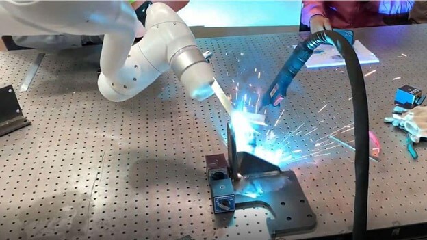 bracket being welded with a smaller cobot